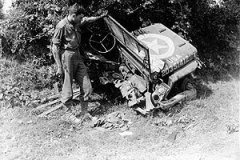 Un soldat américain inspecte une Jeep américaine coupée en deux. année 1944 Lison